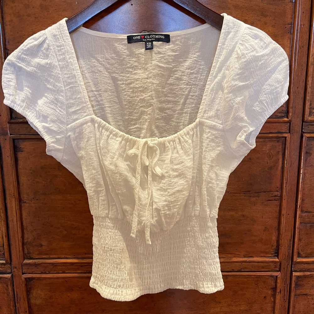 One Love cap sleeve blouse with a cinched neckline and fitted crop waist.